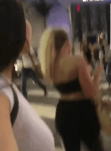 Two woman walking along a street and one of the girls pulls down her mates trousers to reveal her nice ass GIF