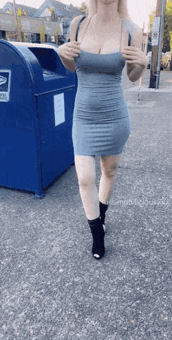A girl walks along a street in a tight grey dress and then flashes her gorgeous big boobs in public.