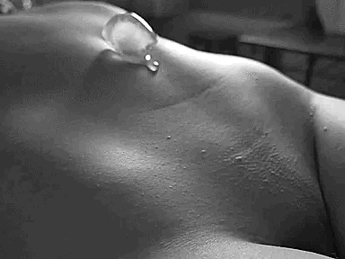 An ice cube melts on girls belly button and it runs down onto her shaved pussy, cooling it down.