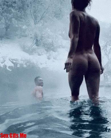 A naked girl walks into a warm spring of water.