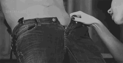 A girl takes a mans dick out of his jeans to give it a lick.